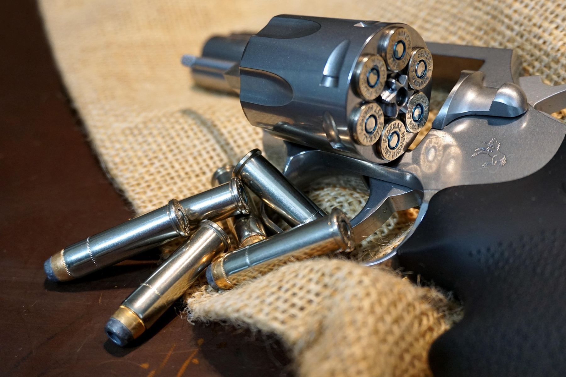Revolver ouvert avec des cartouches sur une toile de jute